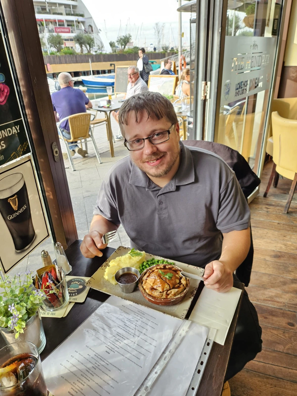 A happy customer enjoying a homemade pie with mash and peas